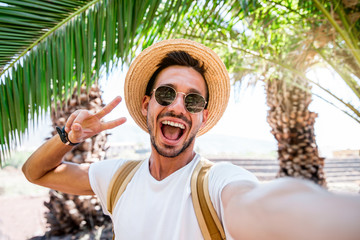 Handsome caucasian man taking a selfie portrait outdoor at vacation. 