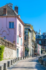 Montmartre in Paris, a very romantic parisian street and buildings, with the basilica Sacre-Coeur in background
