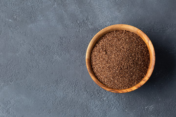 Spa. A scrub of ground coffee and oranges in a wooden bowl made from olive wood on a dark gray background. Space for text.