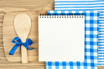 Blue checkered tablecloth and wooden appliances for cooking and baking. Background with copy space. Horizontal.