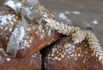 baked rye buns with cereal flakes and ears of wheat