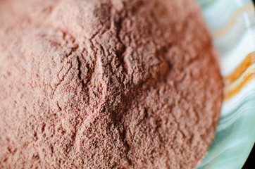 Red bentonite clay powder in the onyx bowl. Diy facial mask and body wrap recipe. Natural beauty treatment and spa. Clay texture close up, selective focus.