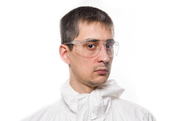 Portrait of young man in protective white medical uniform during coronavirus pandemic. Epidemic, pandemic of coronavirus covid 19.