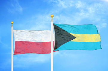 Poland and Bahamas  two flags on flagpoles and blue cloudy sky