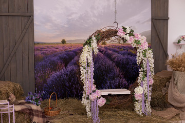 background. swing decorated with Wisteria flowers. photophone with a field of lavender