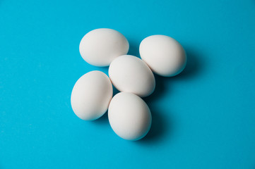 Several eggs on blue background. The concept of calorie content, life, healthy nutrition, Easter