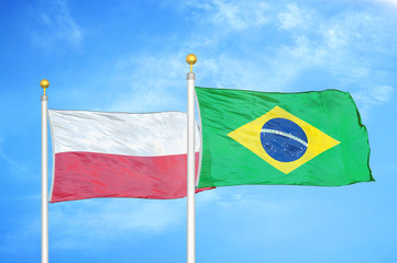 Poland and Brazil  two flags on flagpoles and blue cloudy sky