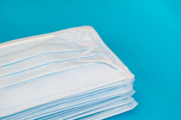 Medical disposable mask, horizontal photo with copy space and blue background. A pack of medical masks close-up.