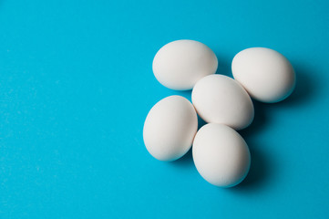 Several eggs on blue background. The concept of calorie content, life, healthy nutrition, Easter