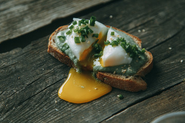  Avocado and mushroom sandwich on a wooden background. Healthy vegetarian food. Bruschetta with avocado and poached egg.
