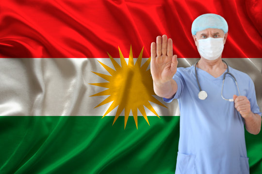 close-up palm of the outstretched hand of a male doctor in a medical mask with a stethoscope on the background of the silk national flag of Kurdistan, rojava, the concept of medical care, quarantine, 