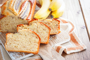 Homemade sliced banana bread on a wooden board, horizontal, copy space