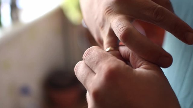 A man takes off a wedding ring.