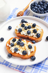 Sandwiches with curd cheese, blueberries and honey