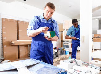 Two male builders working at indoors building site