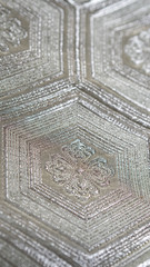 Background with macro closeup on a silver Japanese traditional clothing kimono waistband with hexagon shaped pattern