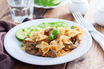 Farfalle with fried chicken liver and carrots, selective focus