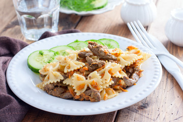 Farfalle with fried chicken liver and carrots, selective focus