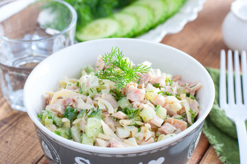 Smoked chicken salad with fresh cucumber in a white bowl, selective focus