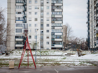 Decaying Basketball playground in front of communist buildings in the district of Novi Beograd, or New Belgrade, in Serbia, in winter, coveredin snow.