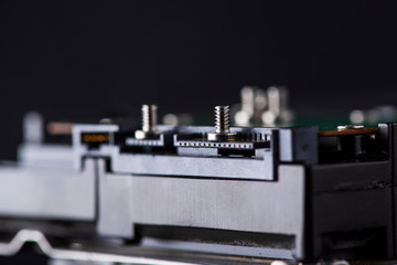 Disassembled hard drive. Spare parts from the hard drive. Photographed close-up against a dark background.