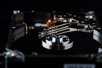 Disassembled hard drive. Spare parts from the hard drive. Photographed close-up against a dark background.