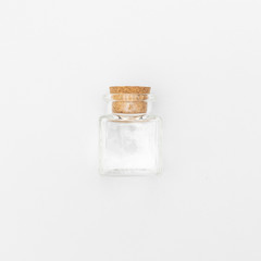 top view of transparent empty glass jar bottle with closed brown cork cap lids on white background