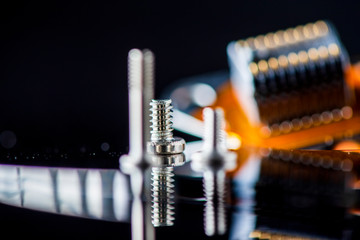 Disassembled hard drive. Spare parts from the hard drive. Photographed close-up against a dark...