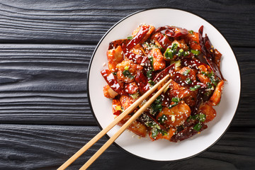 Chinese mala chicken with lots of sichuan pepper closeup in a plate. horizontal top view