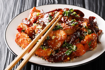 Chinese mala chicken with lots of sichuan pepper closeup in a plate. horizontal