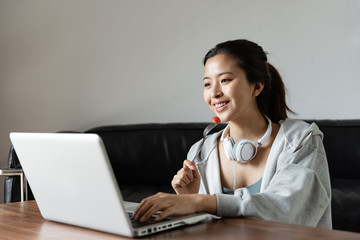 A young Asian woman using a computer in the living room
