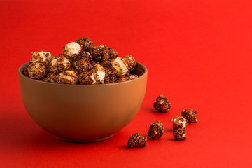 chocolate popcorn in brown plate red background