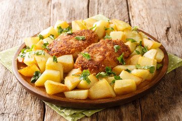 Recipe for Pozharsky chicken cutlets with fried potatoes close-up in a plate. horizontal

