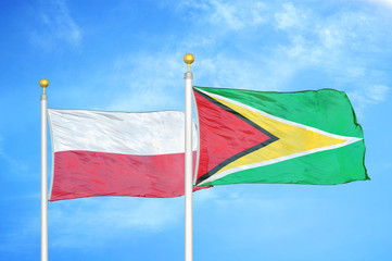Poland and Guyana two flags on flagpoles and blue cloudy sky