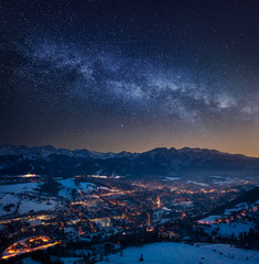 Illuminated Zakopane in winter at night and milky way