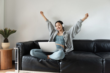 A young Asian woman using a computer in the living room