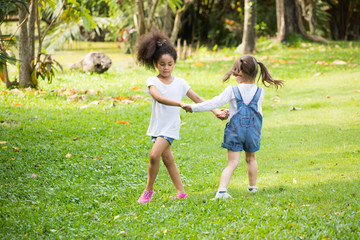 Fototapeta premium smiling kids happily playing and running together on green lawn