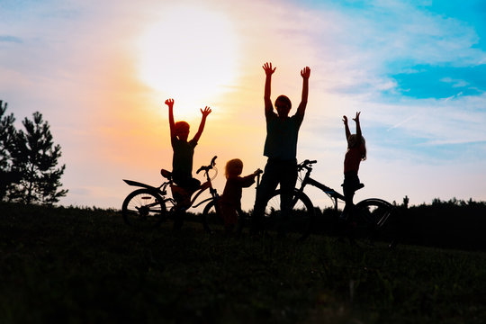 Happy Family On Bikes And Scooter At Sunset Nature, Dad And Kids Exercise In Nature