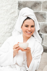 Salt air treatment in the salt room. Beautiful positive woman drinking tea and being treated at the...
