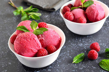 Raspberry ice cream scoop with fresh raspberries in bowl