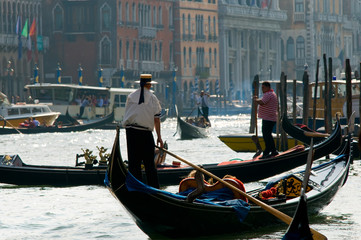 Fototapeta na wymiar Gondolas and gondoliers in the Grand Canal in Venice Italy. Art, travel, and tourism concept.