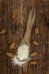 Portion of healthy Ground Almonds on an old wooden table (selective focus; close-up shot)