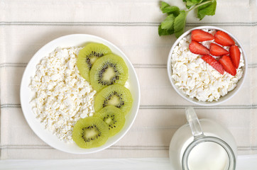 Cottage cheese and kiwifruit. Cottage cheese and strawberry in white bowl