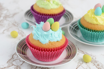 closeup easter cupcake with blue frosting and mini eggs