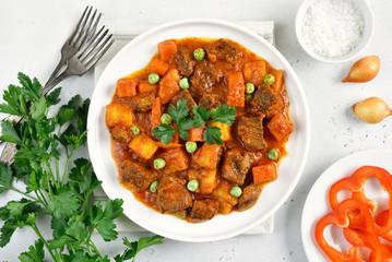 Beef stew with potatoes and carrots in tomato sauce