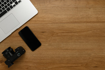 Laptop computer,  Smart phone and mirrorless camera on wooden table, Flat lay