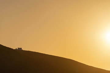 An isolated traditional house in the hills of Serifos island Cyclades Aegean Greece in golden warm light during sunset