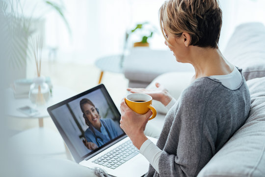 Woman using laptop and having video call with her doctor while sitting at home.