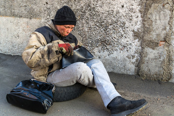 Homeless dirty woman happy that she found a handbag