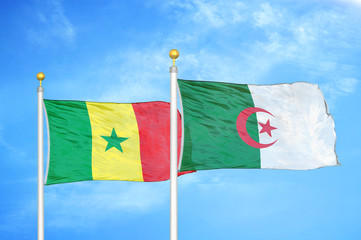 Senegal and Algeria  two flags on flagpoles and blue cloudy sky